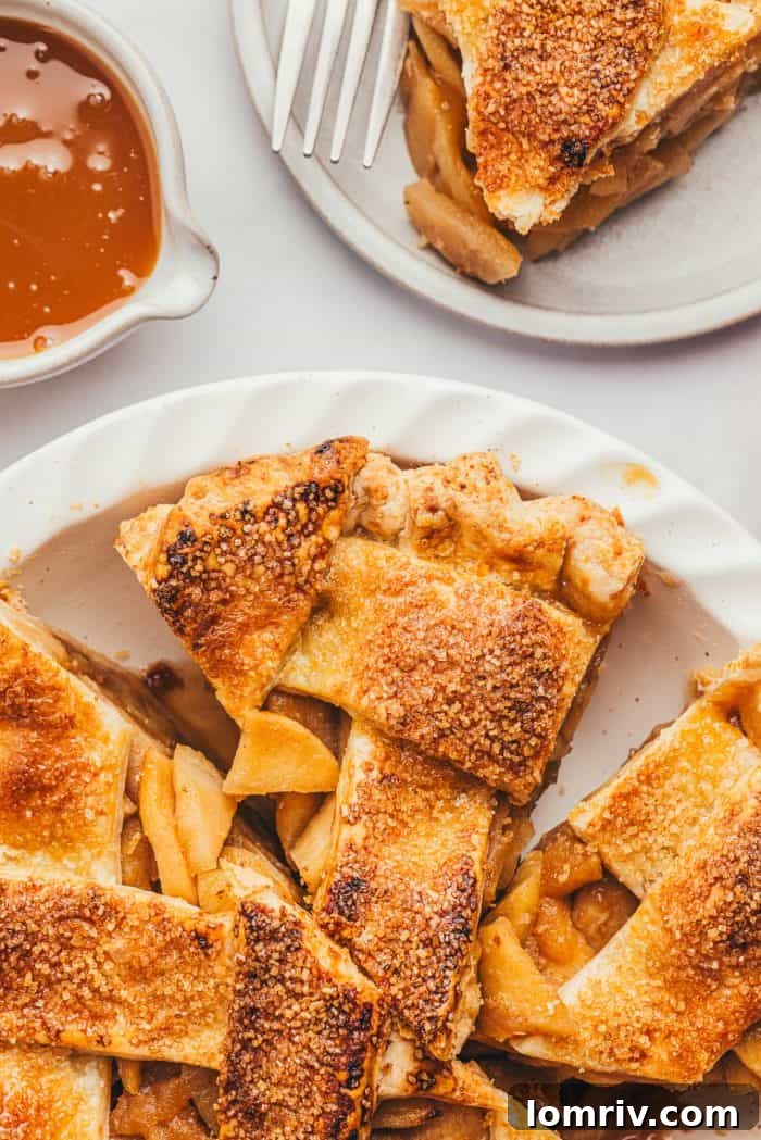 Three generous slices of a beautifully baked apple pie are arranged in a white pie dish, showcasing their golden crusts and rich fillings.