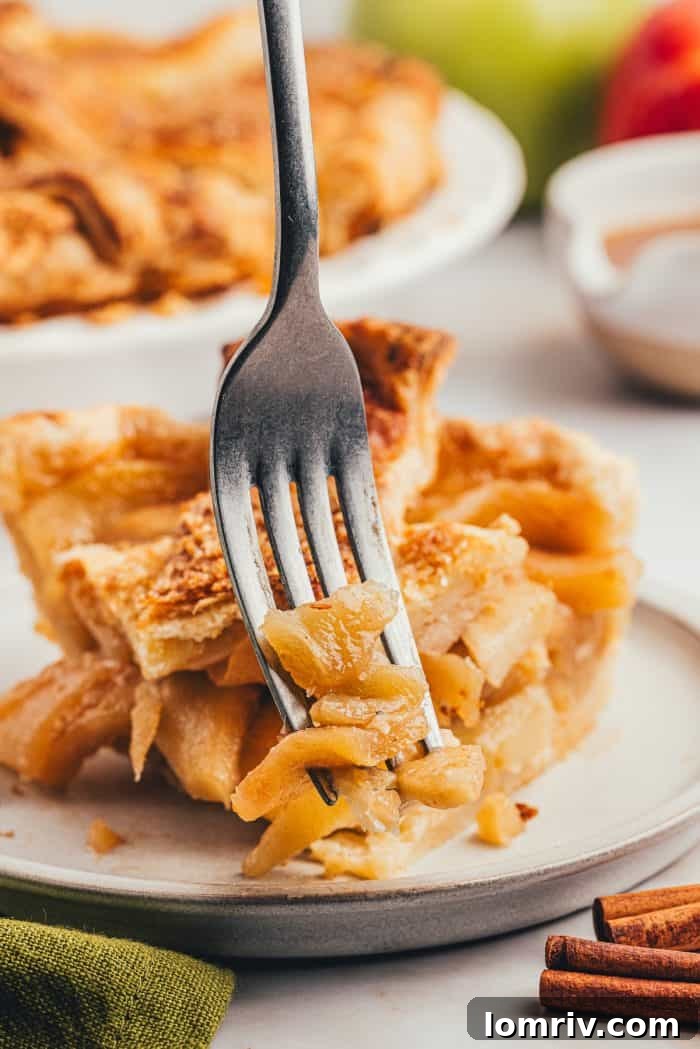 A fork taking a delicious bite out of a slice of homemade apple pie, capturing the moment of indulgence.
