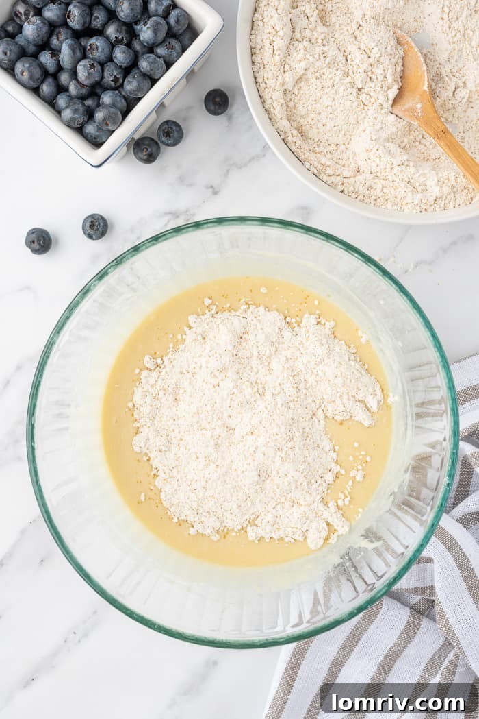 Mixing dry ingredients into wet ingredients for Mini Coconut Cupcakes