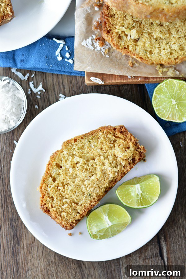 Three slices of Coconut Lime Zucchini Bread on a plate with lime