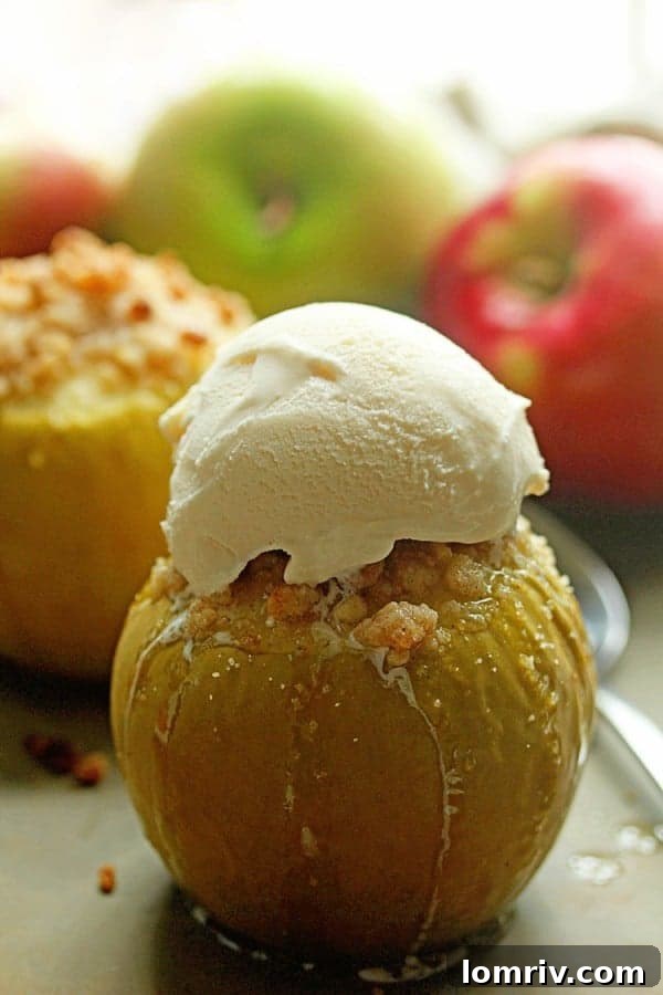 A close-up view of a baked apple, richly filled with a sweet brown sugar and butter mixture, topped with a golden crumble.