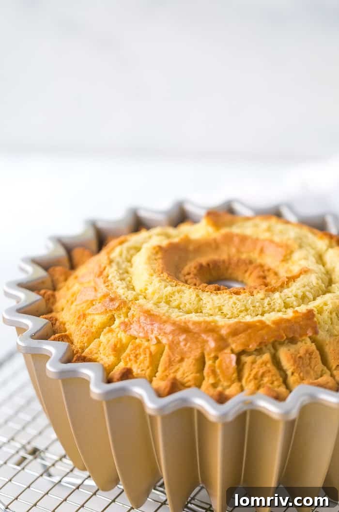 A close-up of the moist interior of the Coconut Bundt Cake, revealing its fluffy texture and visible shreds of coconut. It hints at the rich, authentic coconut flavor.