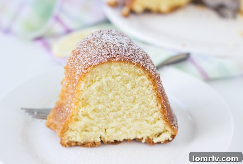 A perfectly sliced piece of 7UP Pound Cake, showcasing its incredibly tender crumb and delicate lemon glaze.
