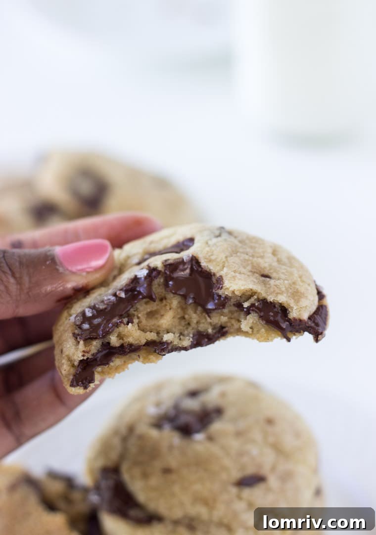 Two dairy-free coconut chocolate chunk cookies stacked, showing their thick texture.