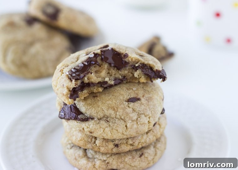Close-up of a warm coconut chocolate chunk cookie with melted chocolate and sea salt.