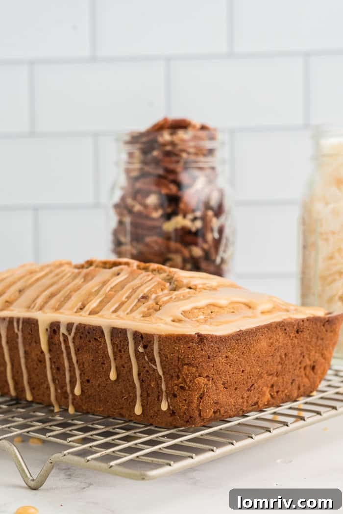 Moist and flavorful Coconut Apple Bread loaf with a rich caramel glaze, perfect for a cozy morning or holiday gathering.