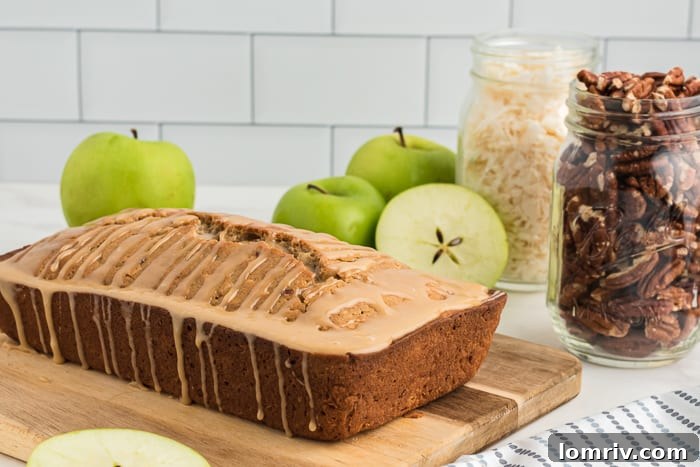 A perfectly sliced piece of Coconut Apple Bread, revealing a tender crumb studded with apple chunks, coconut flakes, and crunchy nuts.