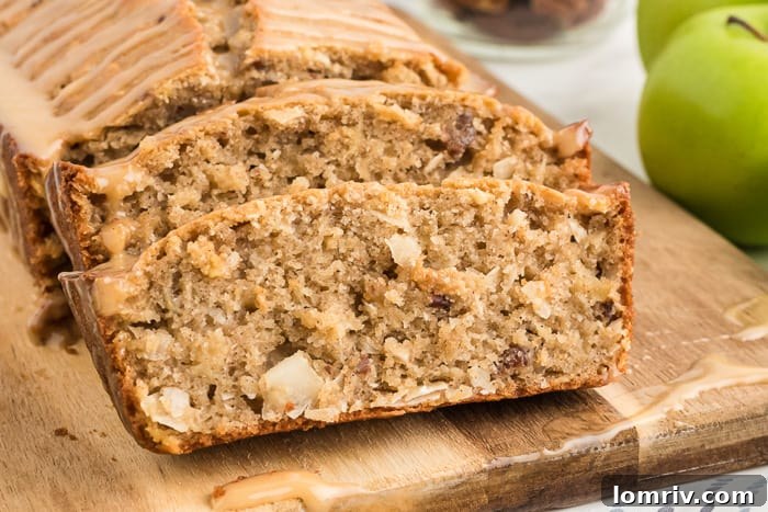A close-up of a warm, fresh slice of Coconut Apple Bread, ready to be enjoyed.