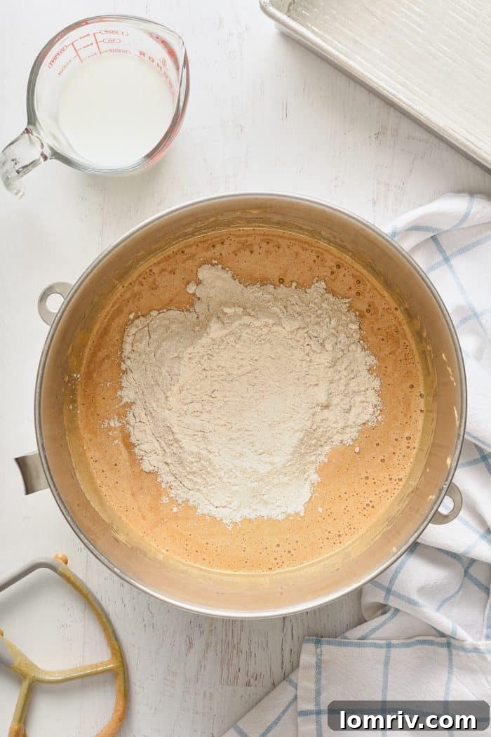 Adding dry ingredients to the batter in stages.