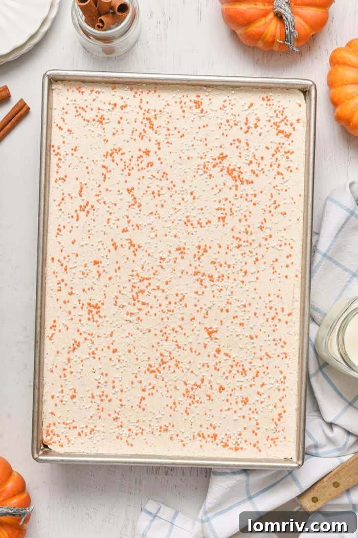 Frosted cake decorated with festive orange and white sprinkles.