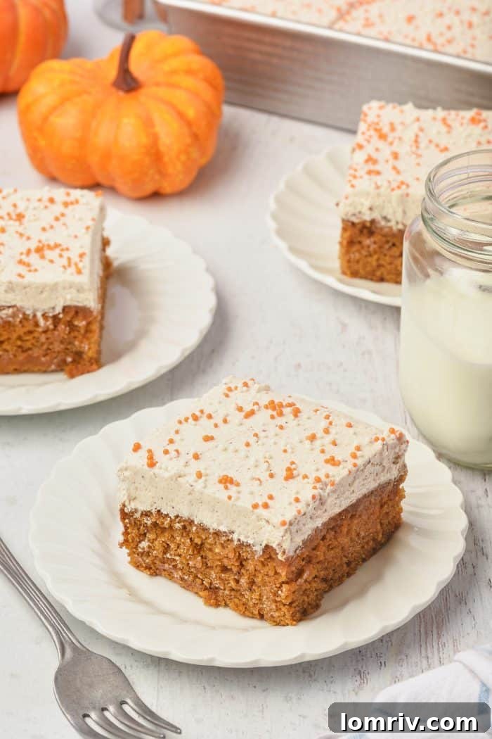 Three white plates with pumpkin cake bars and a glass of milk, invitingly arranged.