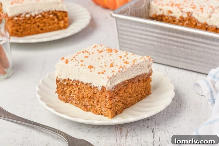 A closeup of a single pumpkin cake bar, highlighting the texture and frosting.