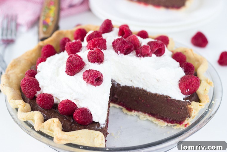 A full Raspberry Mocha Pie, elegantly garnished with fresh raspberries and a swirl of whipped cream, ready to be served.
