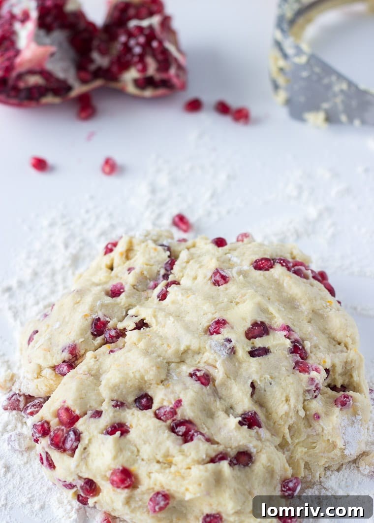 Close-up shot of freshly baked Pomegranate Orange Scones, highlighting their golden crust and juicy pomegranate seeds.
