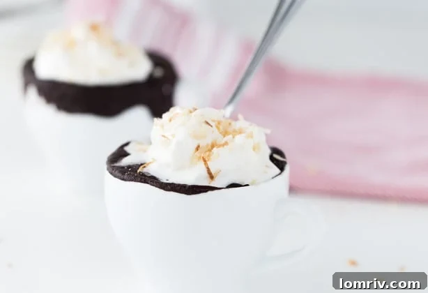 Chocolate Coconut Mug Cake with coconut cream and flakes