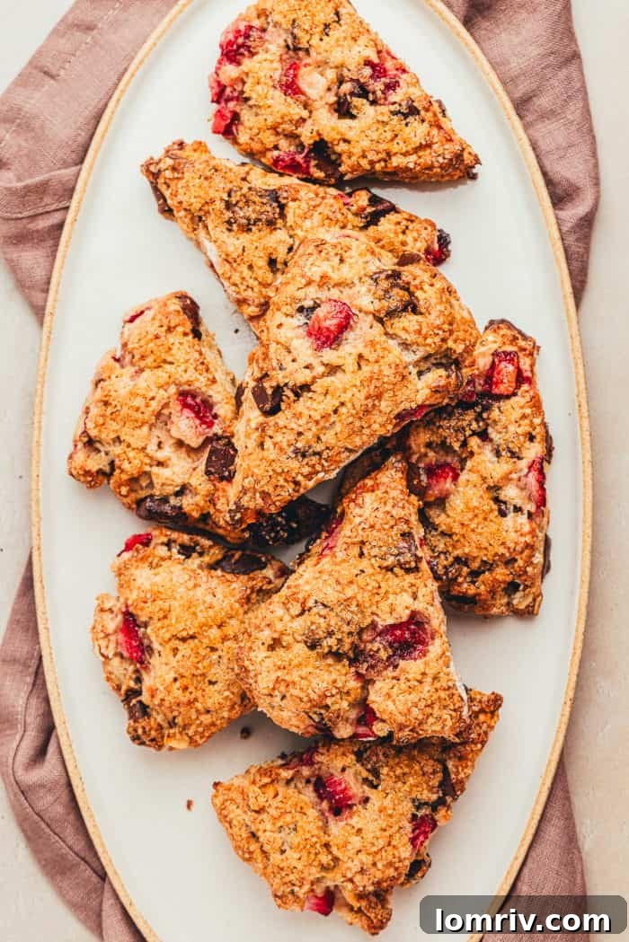 A few chocolate strawberry scones on a white platter.