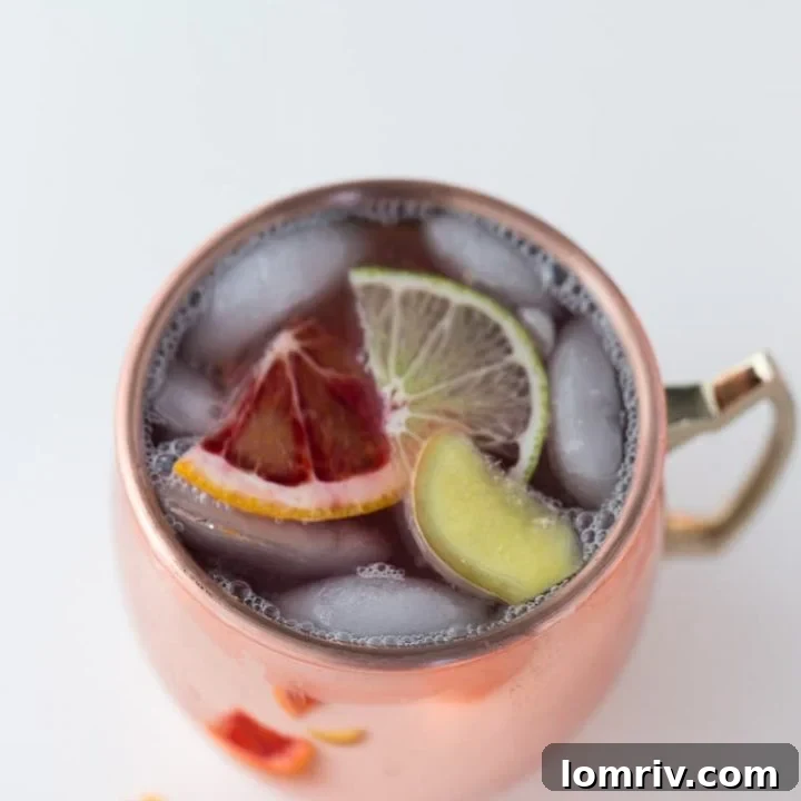The finished Blood Orange Moscow Mule ready to be enjoyed, showing off its beautiful color and garnishes.
