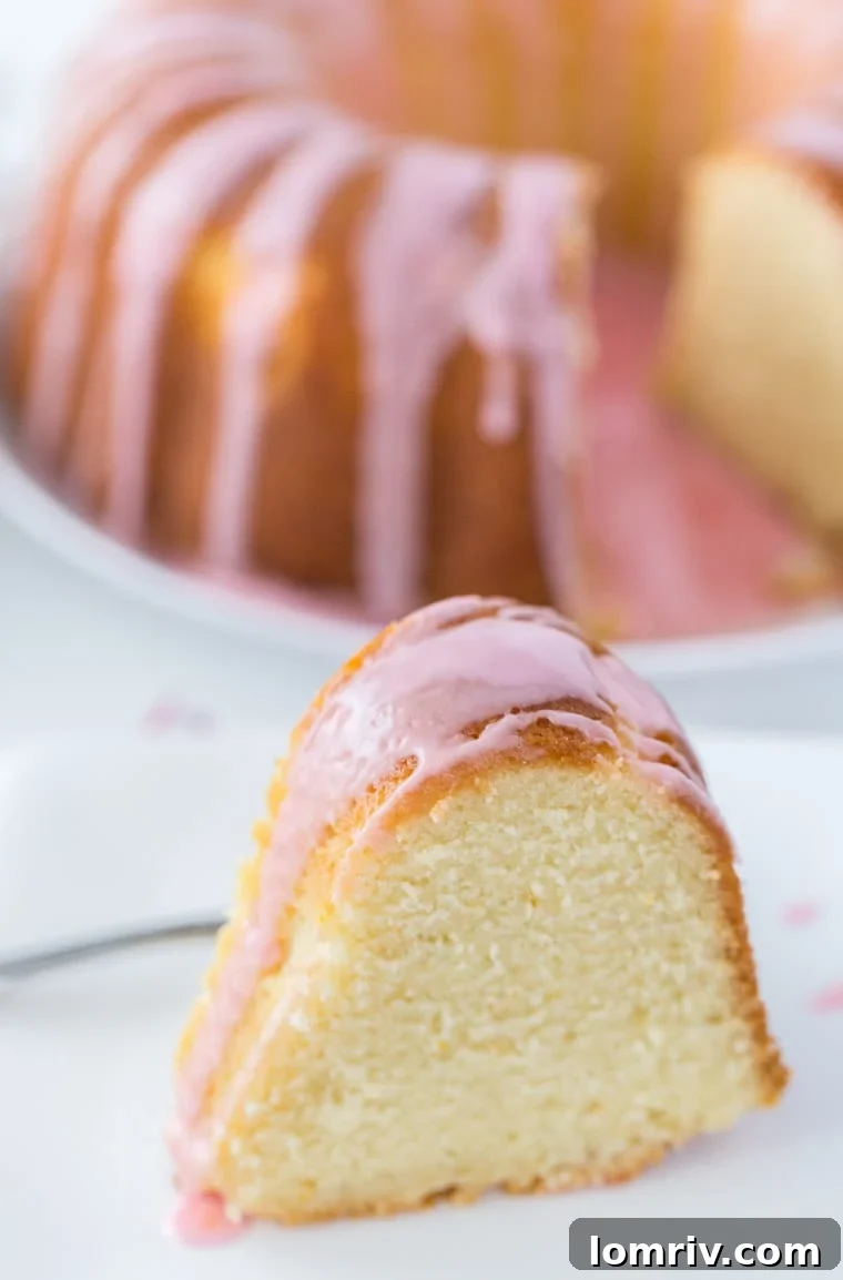 A slice of Blood Orange Mimosa Cake, showcasing its fluffy crumb and delicate pink hue, ready to be served.