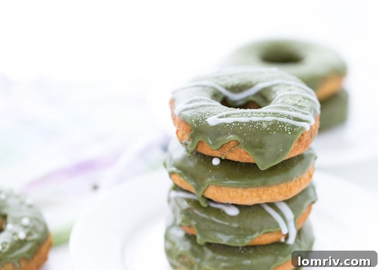 Close-up of a homemade Coconut Matcha Donut, showcasing its soft texture and vibrant green glaze.