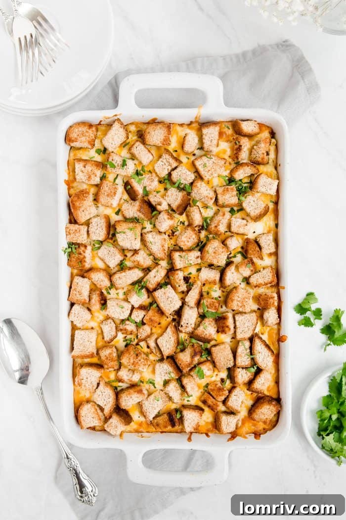 Rich, golden-brown Spicy Macaroni and Cheese in a baking dish, topped with crispy croutons and fresh parsley.