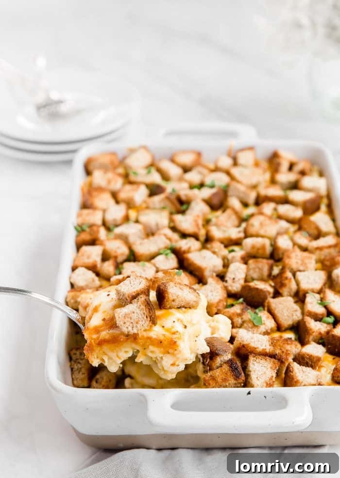 Spicy Macaroni and Cheese with a spoon digging into the creamy, cheesy pasta with crispy croutons.