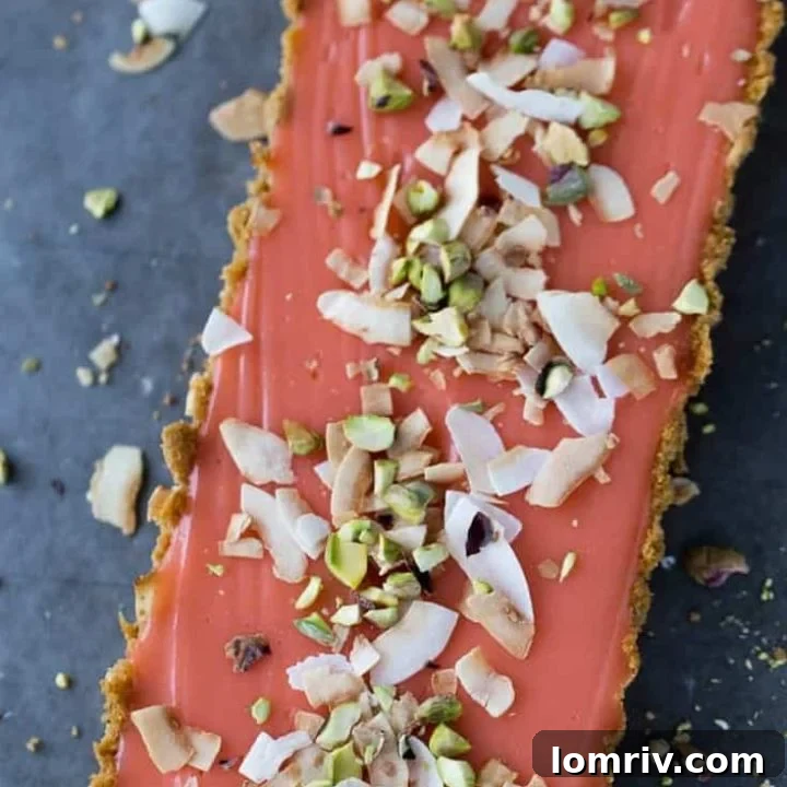 A perfectly baked Grapefruit Tart with a golden coconut graham cracker crust and a smooth, pale pink grapefruit curd.