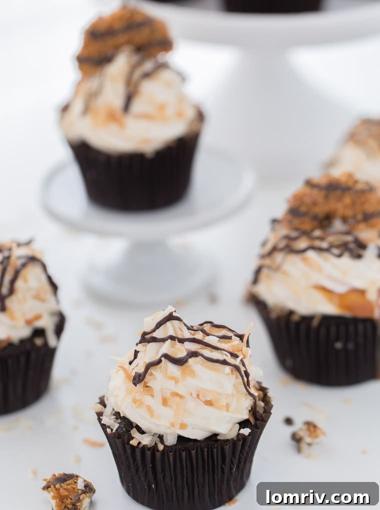 These Samoa cupcakes start with chocolate coconut cupcakes with caramel coconut frosting garnished with coconut flakes and chocolate drizzles.