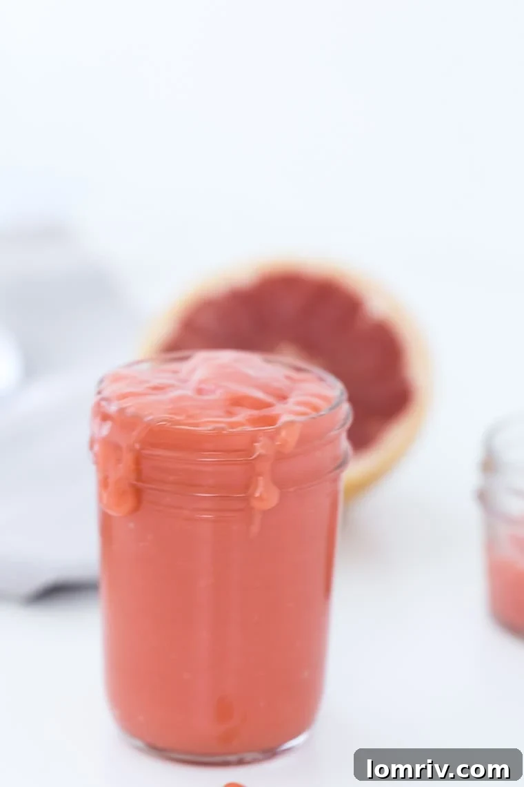 A beautifully arranged homemade grapefruit tart, featuring a golden crust and a vibrant, smooth grapefruit curd filling. Perfect for dessert lovers.