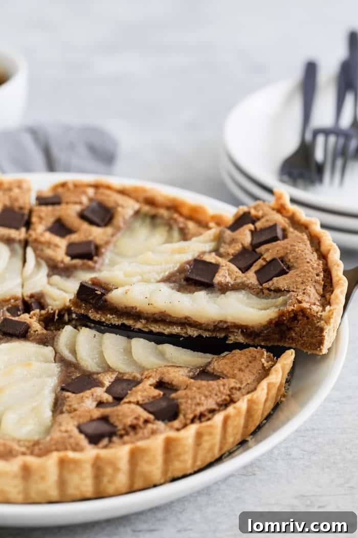 A wider shot of the Pear Walnut Chocolate Tart, featuring a slice removed, highlighting the depth of the filling and the crispness of the crust. The inviting presentation makes it an ideal dessert for any gathering.
