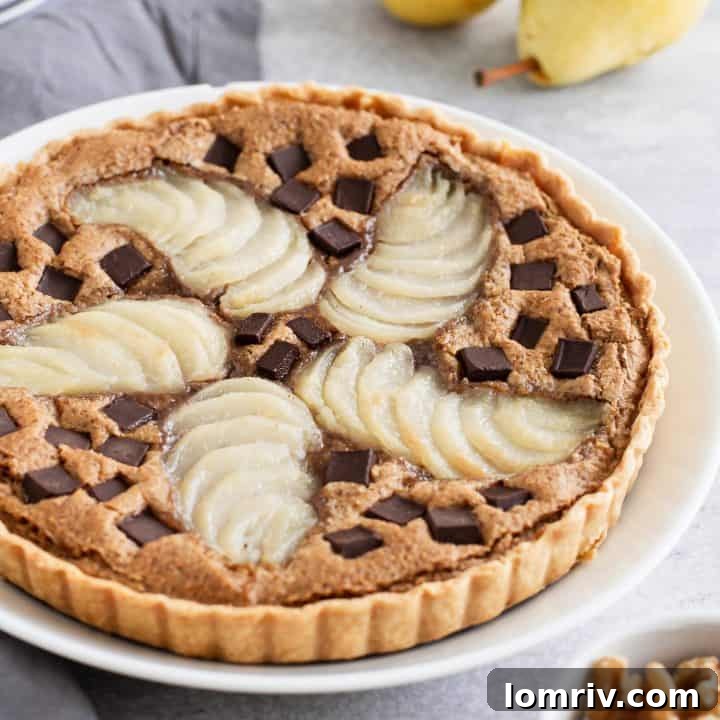 Pear Walnut Chocolate Tart, a unique dessert with a flaky crust, smooth walnut paste, tender poached pears, and rich chocolate.