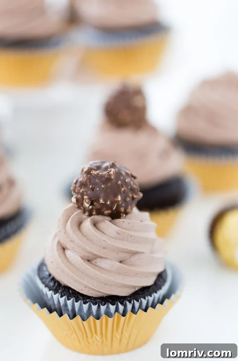 Decadent Ferrero Rocher Cupcakes with creamy whipped Nutella frosting and a delightful hidden surprise inside.