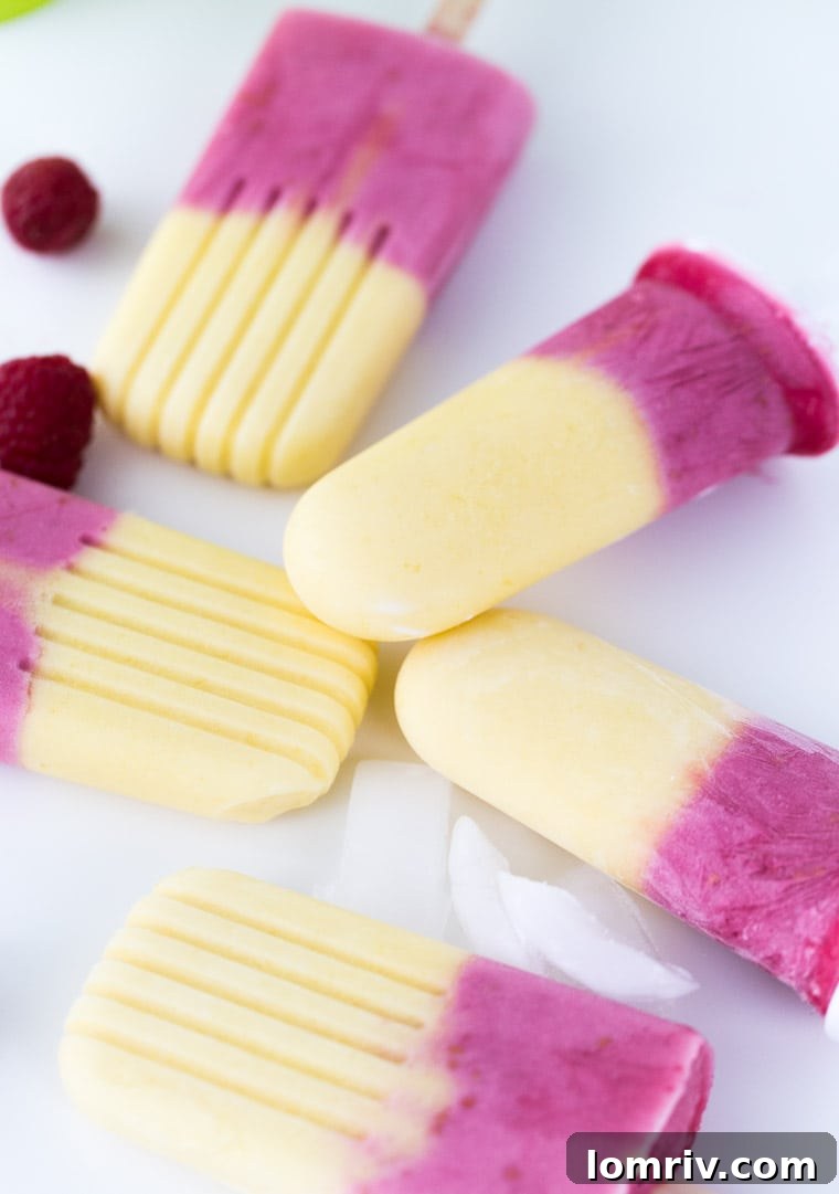 Close-up of a raspberry mango yogurt pop showing distinct layers of vibrant fruit and creamy yogurt, a delicious and healthy snack.