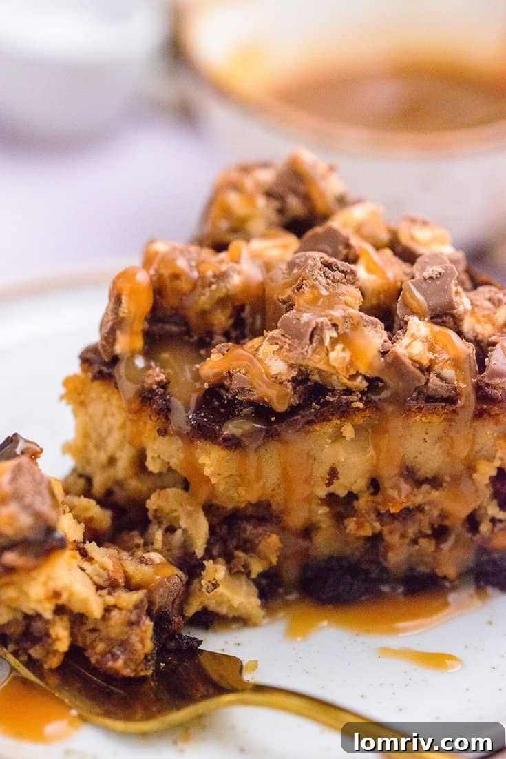 Sliced Snickers Peanut Butter Cheesecake ready to be served