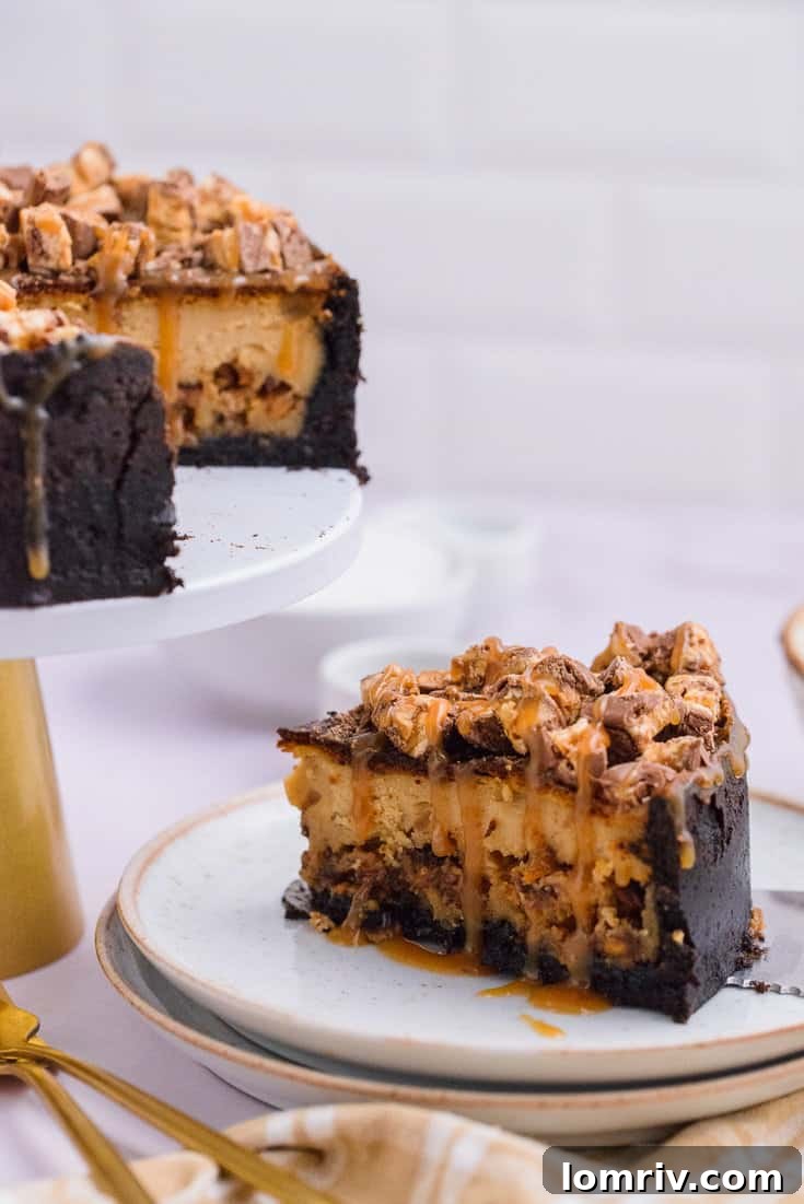 Elegant shot of Snickers Peanut Butter Cheesecake with a spoon