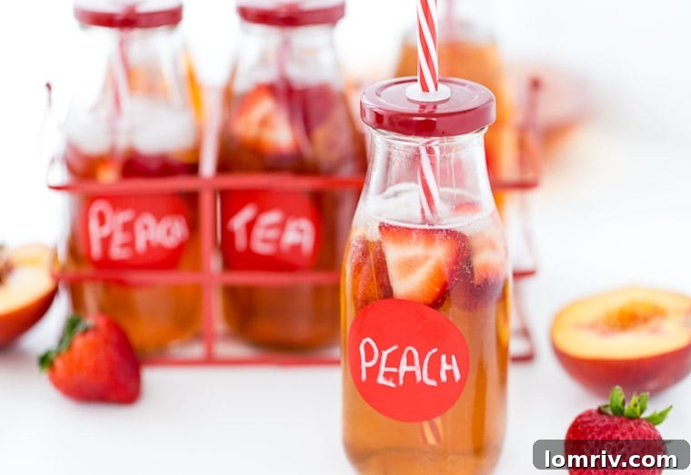 Close-up of a glass of Strawberry Peach Iced Tea with fresh fruit garnish