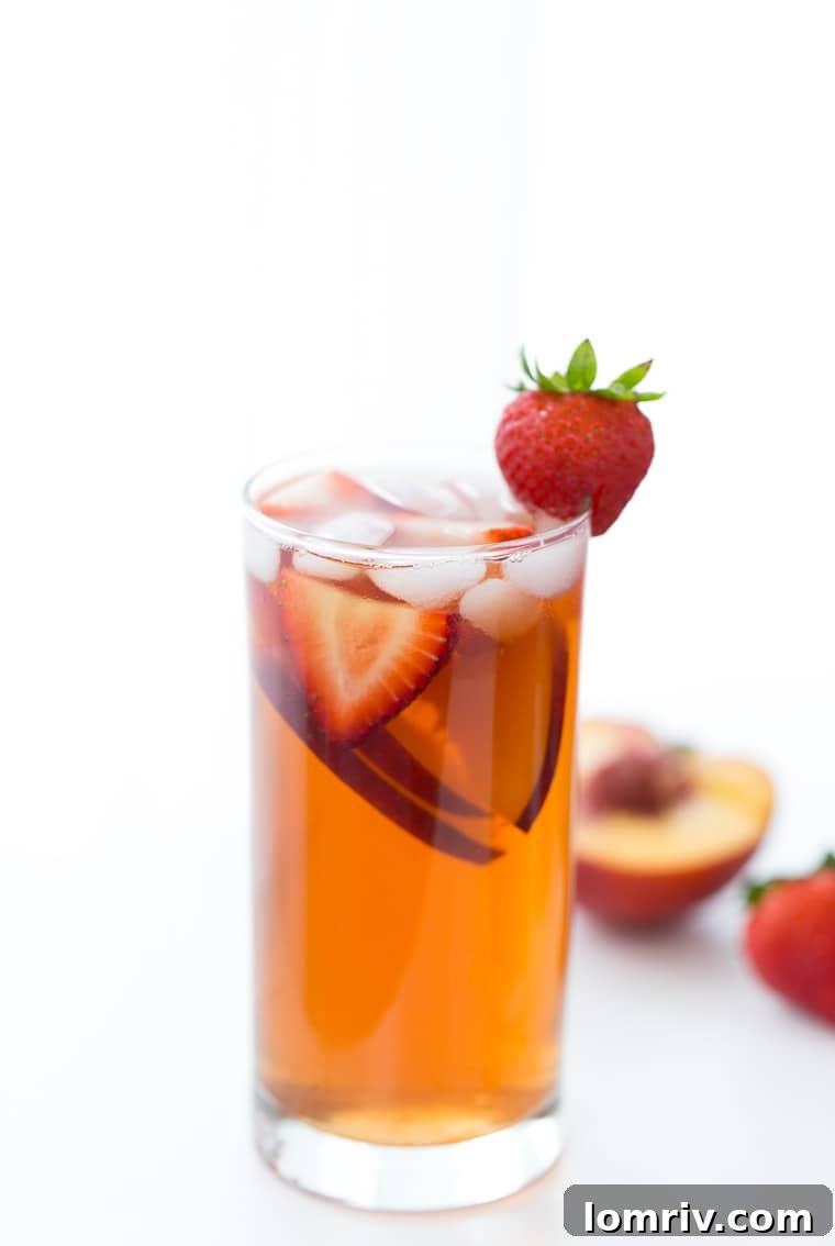 Refreshing Strawberry Peach Iced Tea garnished with fresh fruit, perfect for summer.