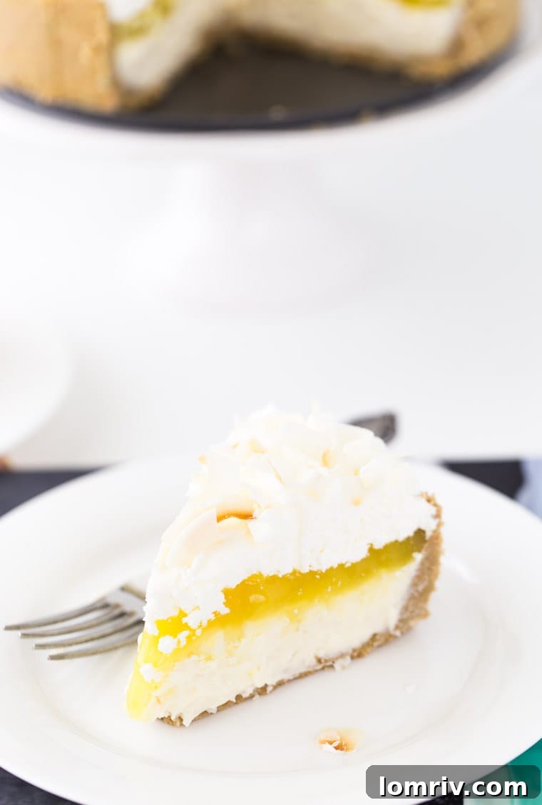 Slice of Lemon Macaroon Cheesecake showcasing delicious layers of golden Oreo crust, creamy coconut filling, and vibrant lemon curd