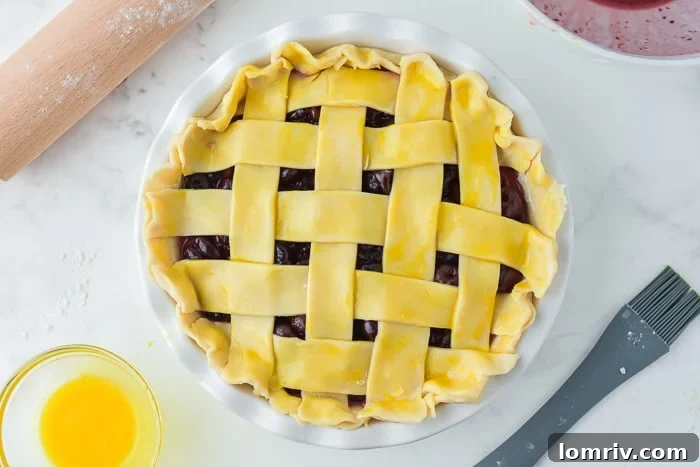 Egg wash and turbinado sugar applied to a cherry pie, ready for the oven
