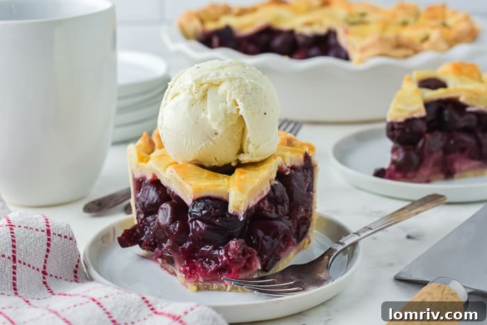 A slice of Cherry Bourbon Pie served with vanilla ice cream