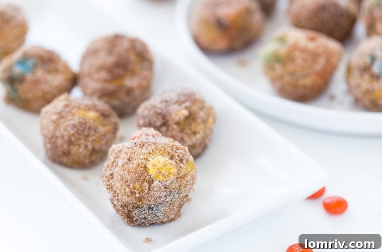 Close-up of freshly baked Pumpkin Spice Donut Holes featuring colorful M&Ms.