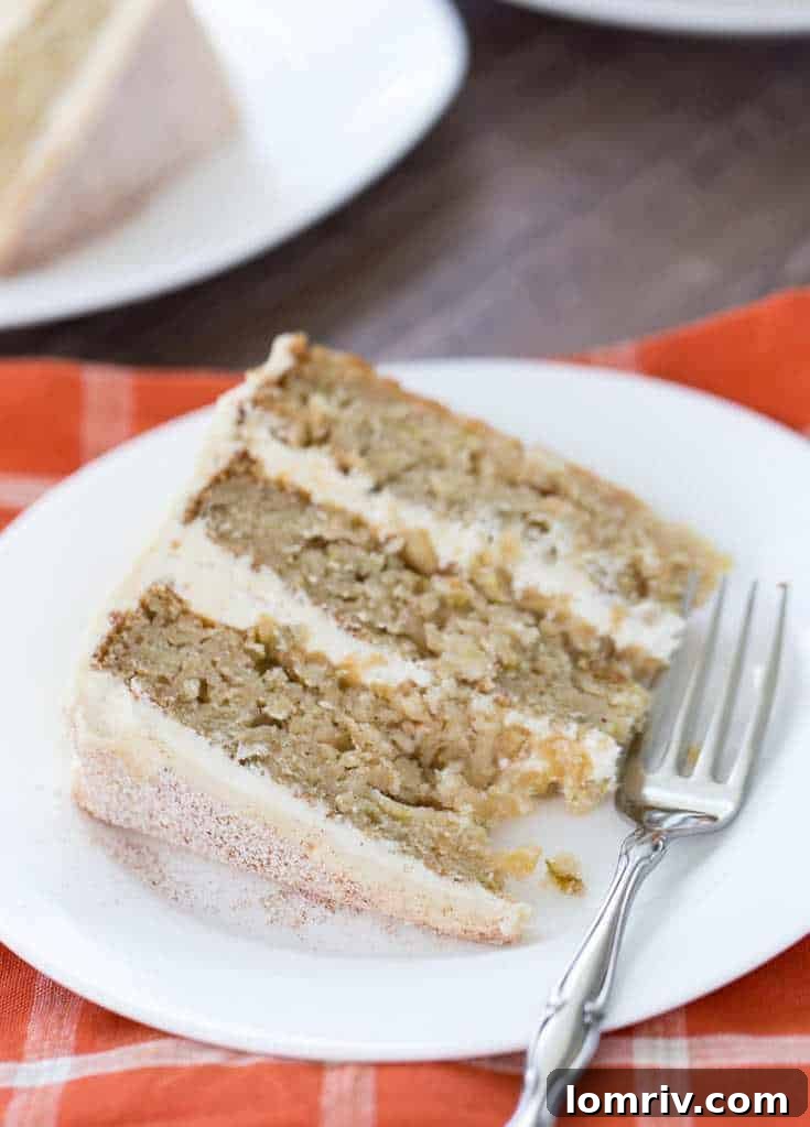 Soft apple cider cake layers with creamy malted vanilla frosting, ready for fall gatherings.
