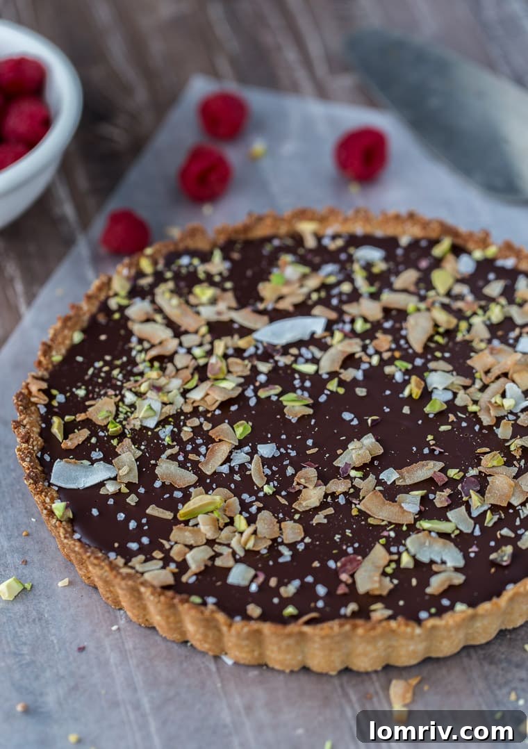 A decadent gluten free and vegan chocolate coconut tart that starts with a chewy coconut almond crust and is filled with creamy chocolate coconut ganache.
