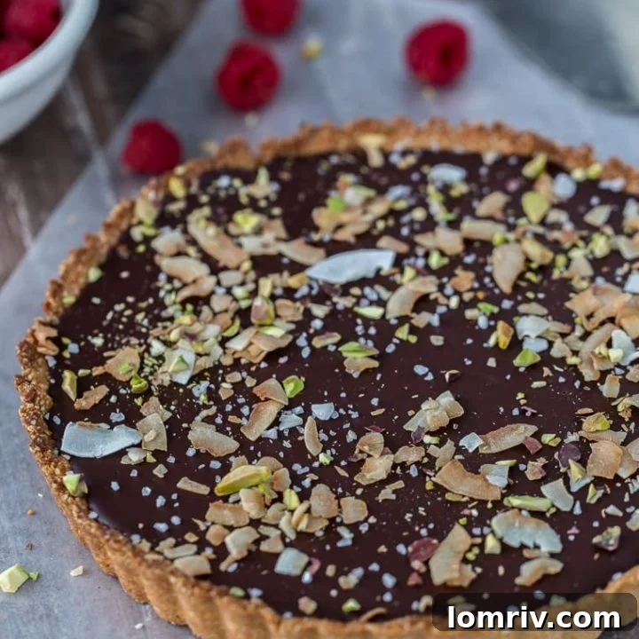 A decadent gluten free and vegan chocolate coconut tart that starts with a chewy coconut almond crust and is filled with creamy chocolate coconut ganache.
