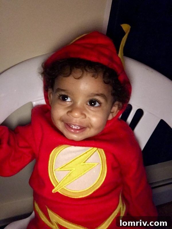 Toddler dressed in a Flash costume enjoying a Halloween party.