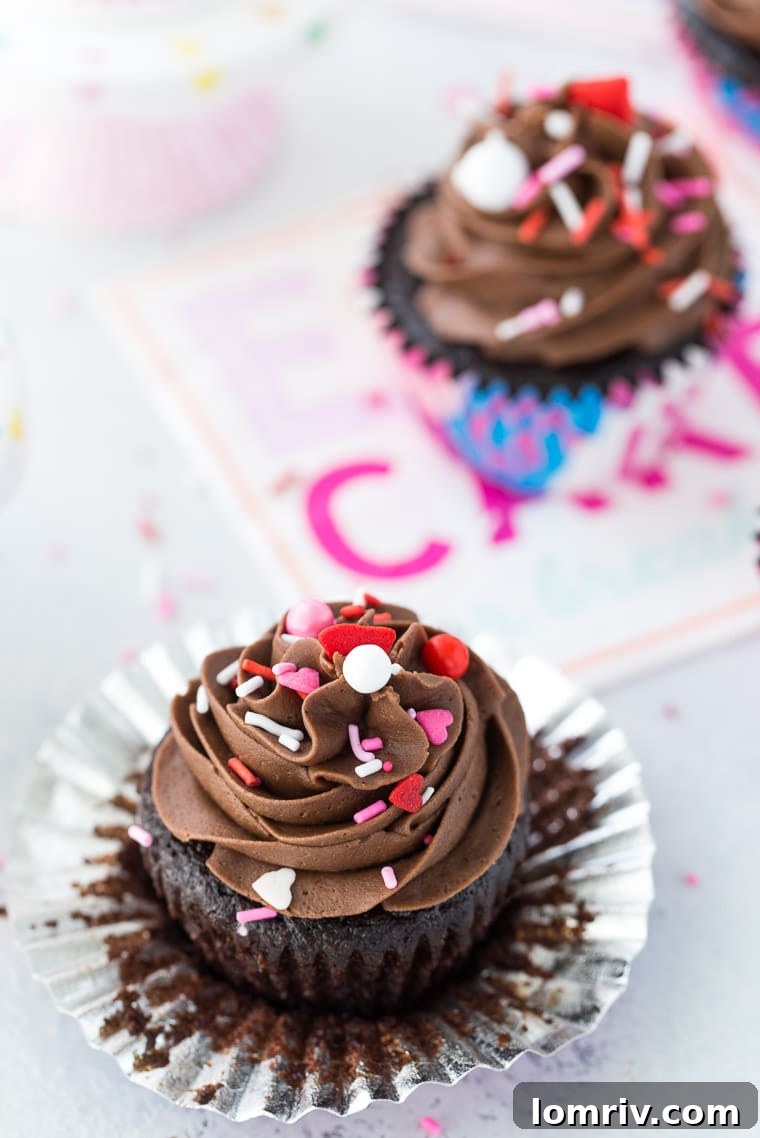 Overhead shot of several rich chocolate cupcakes topped with silky smooth chocolate buttercream, perfect for any occasion.