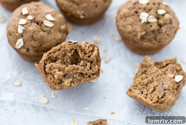 Various banana nut muffins, with one cut open to reveal its texture and nut distribution.