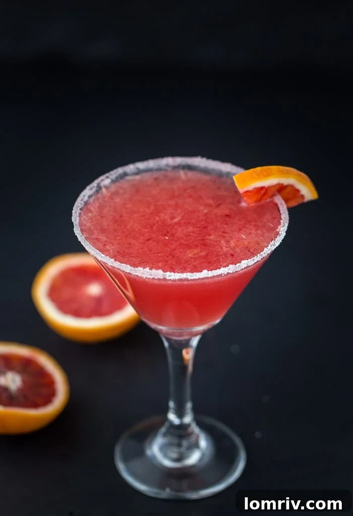 An inviting close-up shot of a Blood Orange Vanilla Martini with a sugar-rimmed glass, ready to be enjoyed.