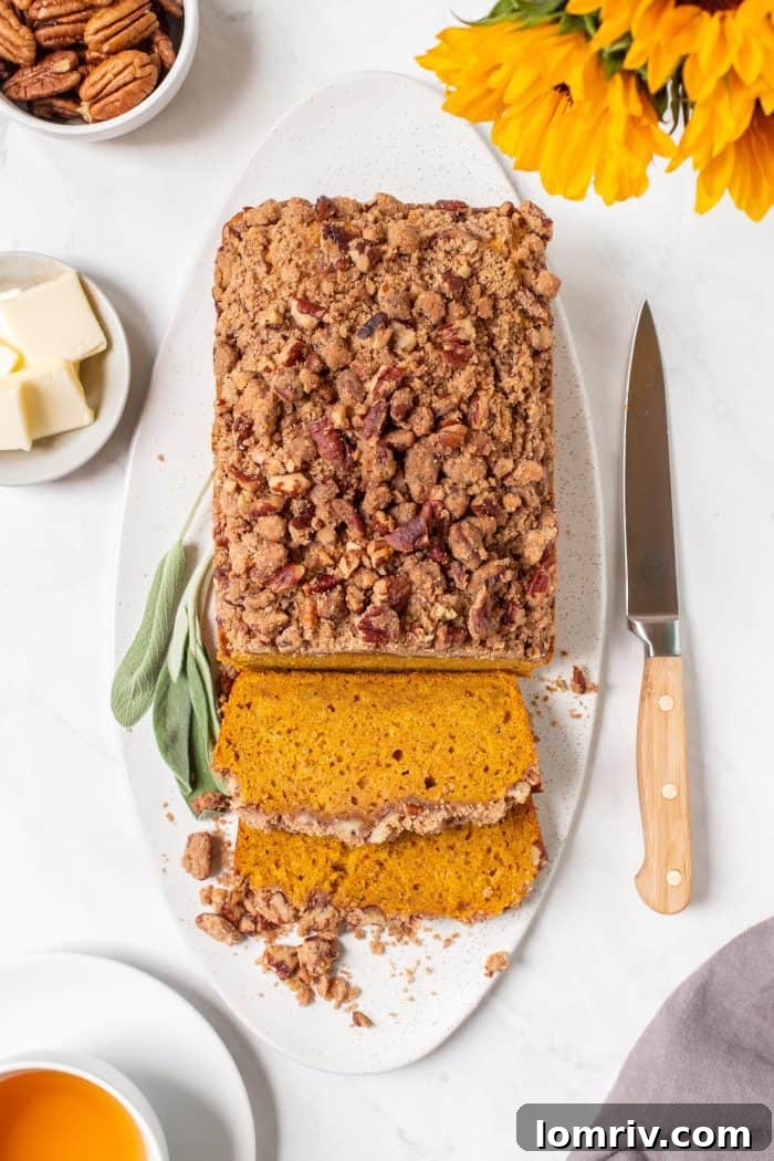 Deliciously moist Brown Butter Pumpkin Sage Bread with a golden streusel topping, ready to be sliced.
