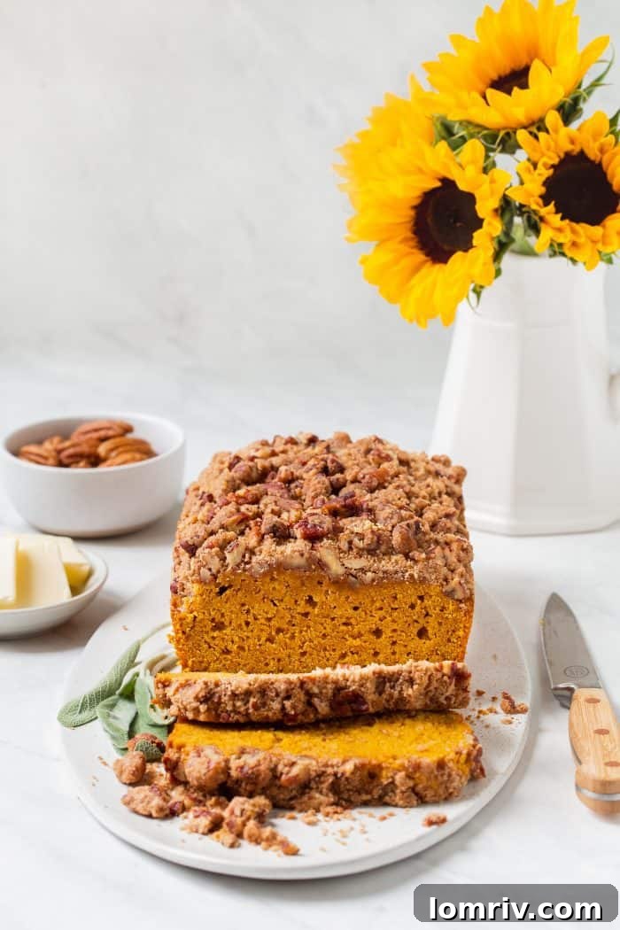 Close-up of a perfectly baked slice of Brown Butter Pumpkin Sage Bread, revealing its moist interior and streusel.