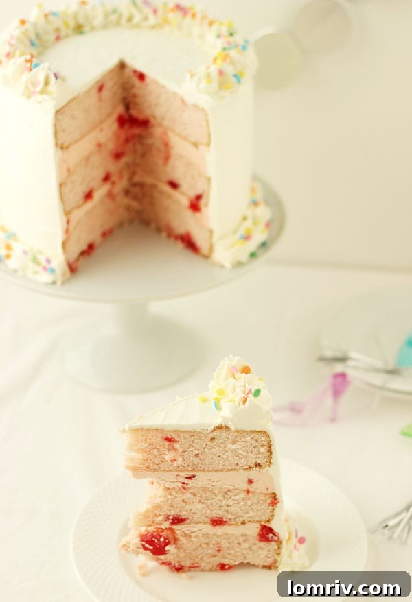 Beautifully decorated Cherry Vanilla Champagne Cake layers, showing the intricate details of this celebratory dessert. Find the recipe at AClassicTwist.com
